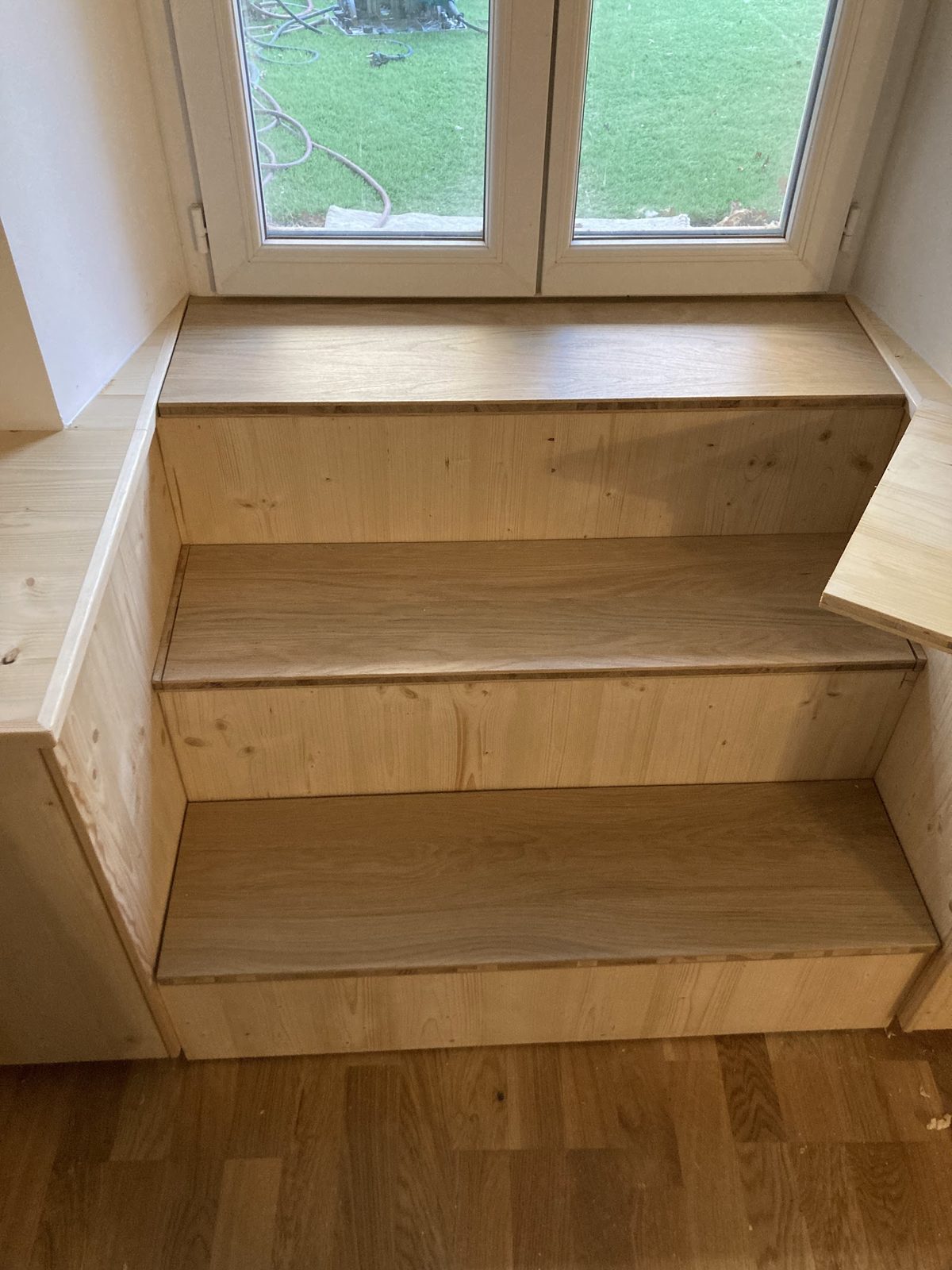 Marches et assise en bois sous une fenêtre
